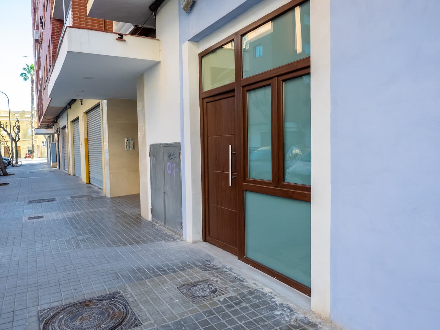 La calle de los estudios, con sus puertas de madera y la fachada azul